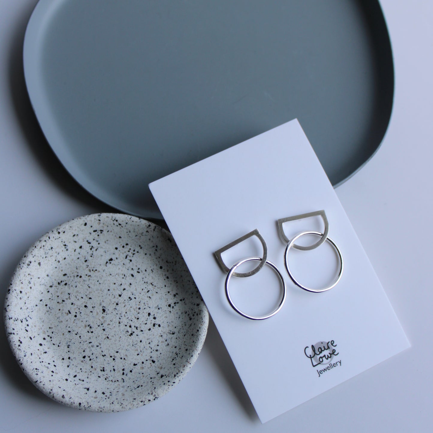 arc and circle stud earrings on an earring card