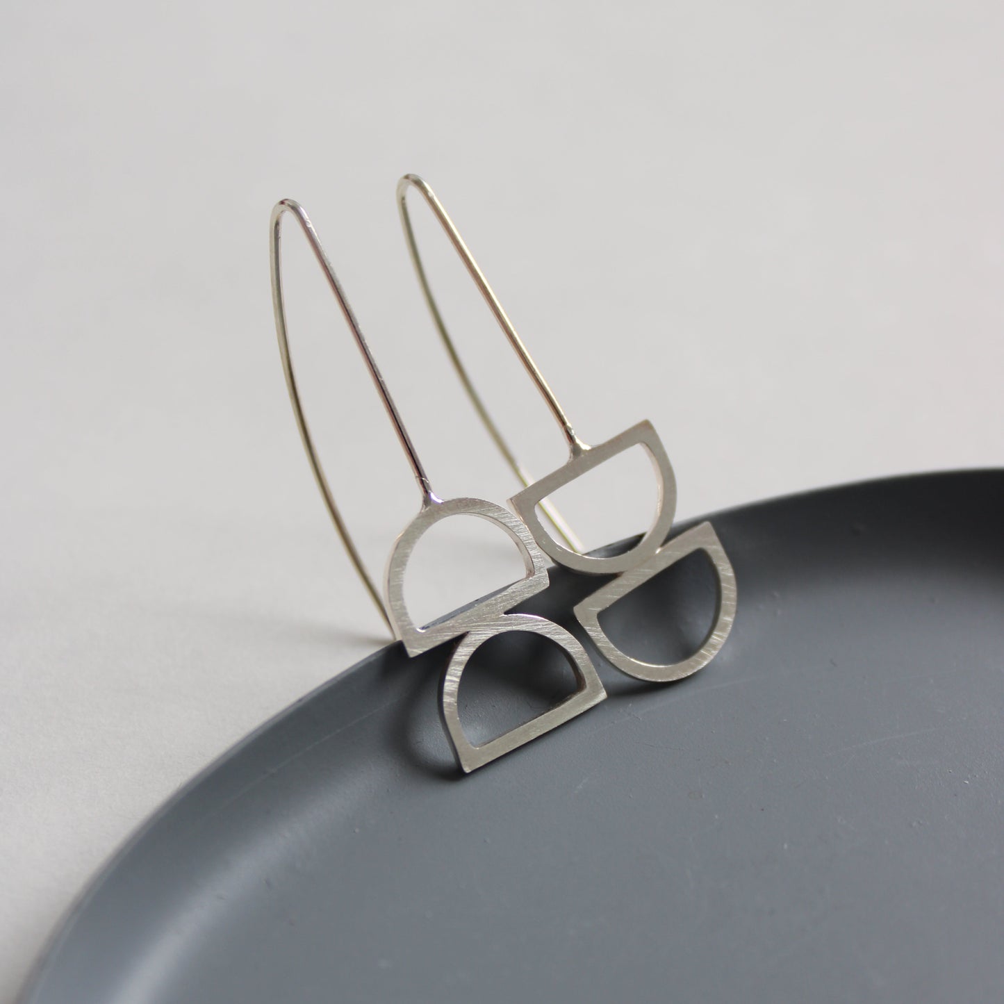silver odd arc drop earrings