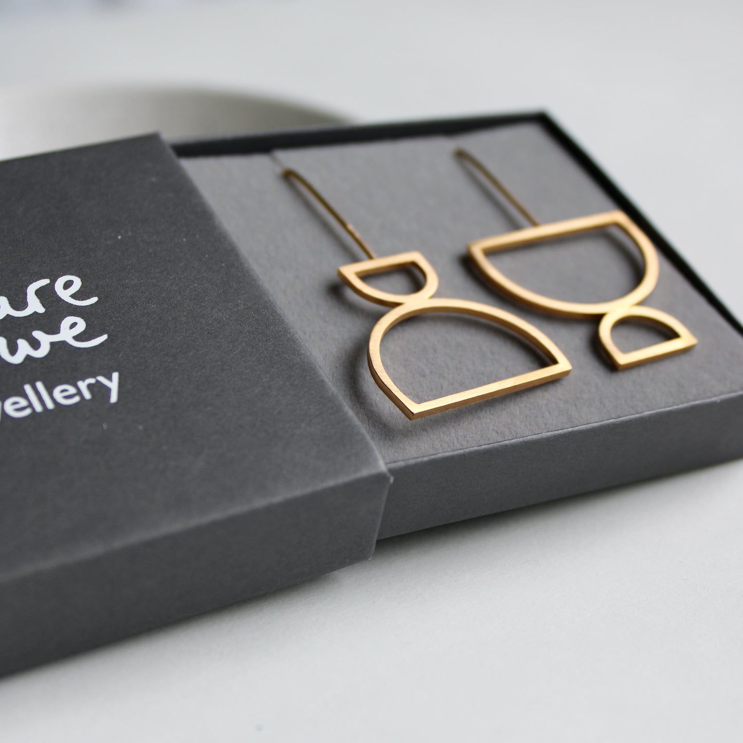 arc odd drop earrings in gold vermeil, box from side view