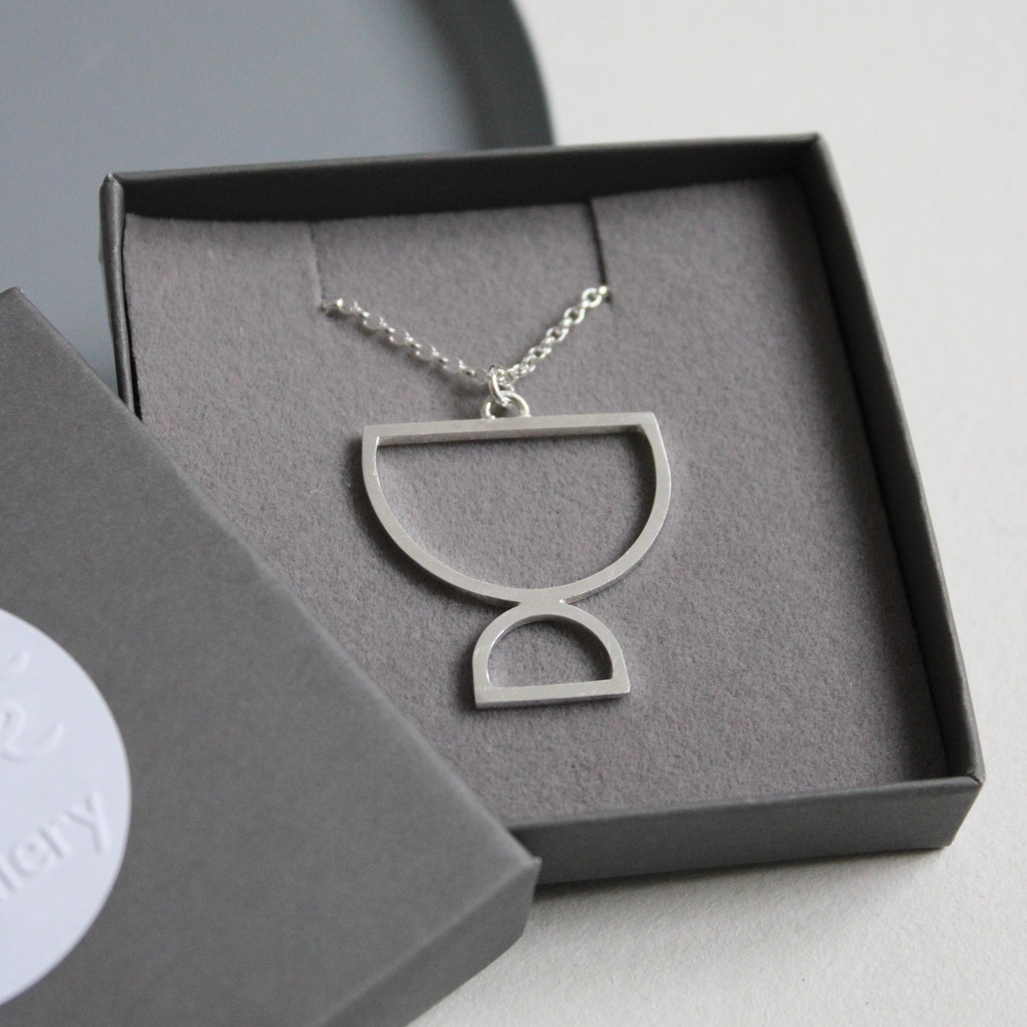 silver double arc pendant in box