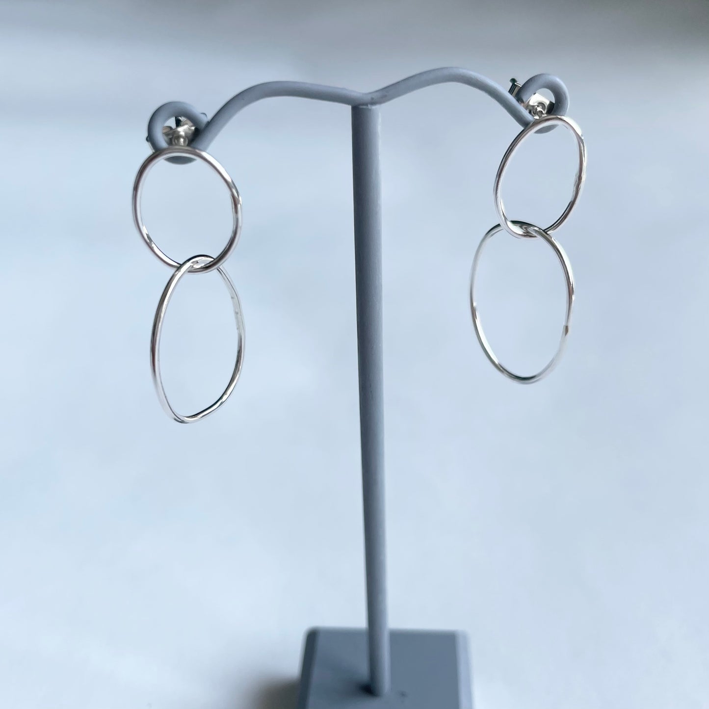 silver pebble earrings on earring stand