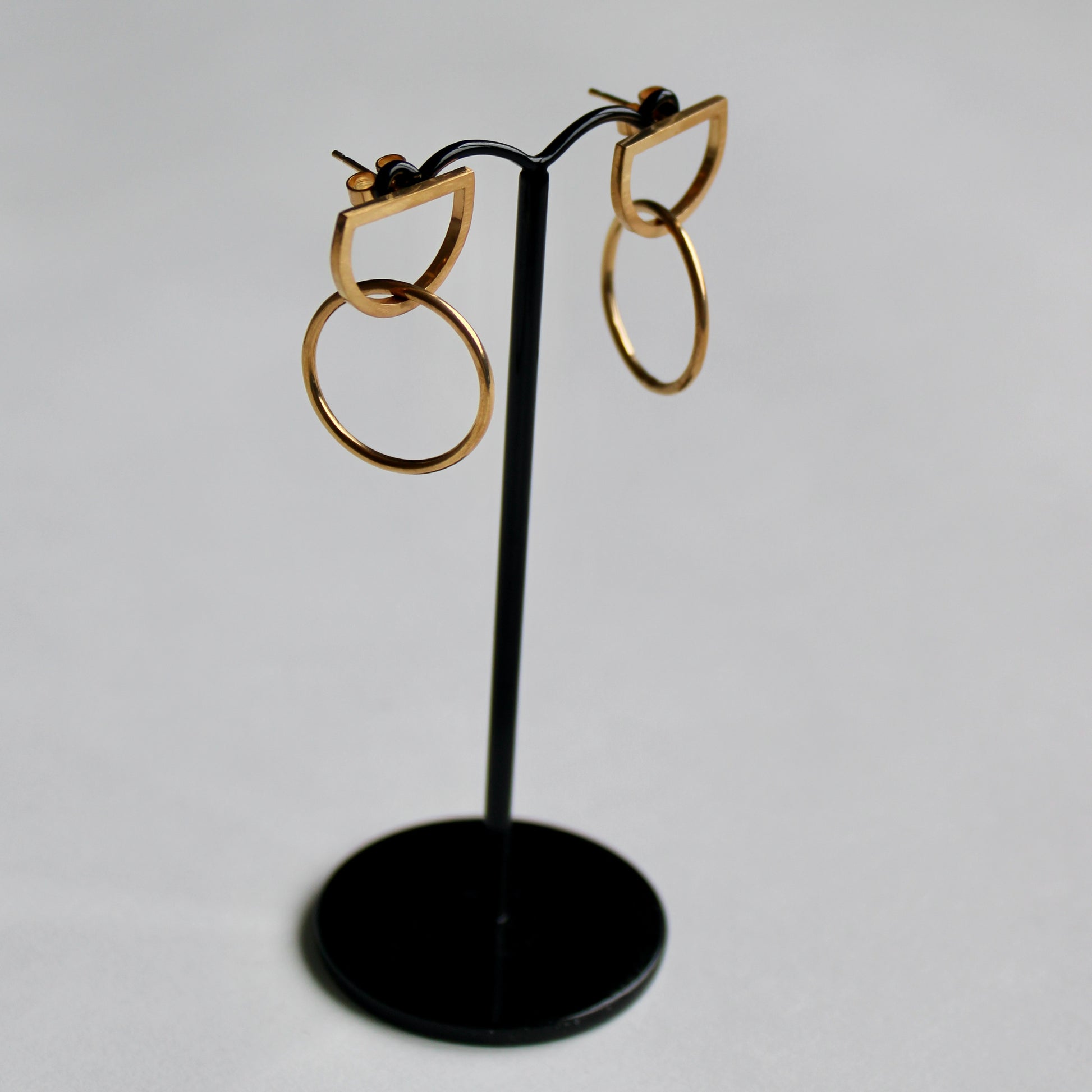 arc circle earrings in gold vermeil on an earring stand
