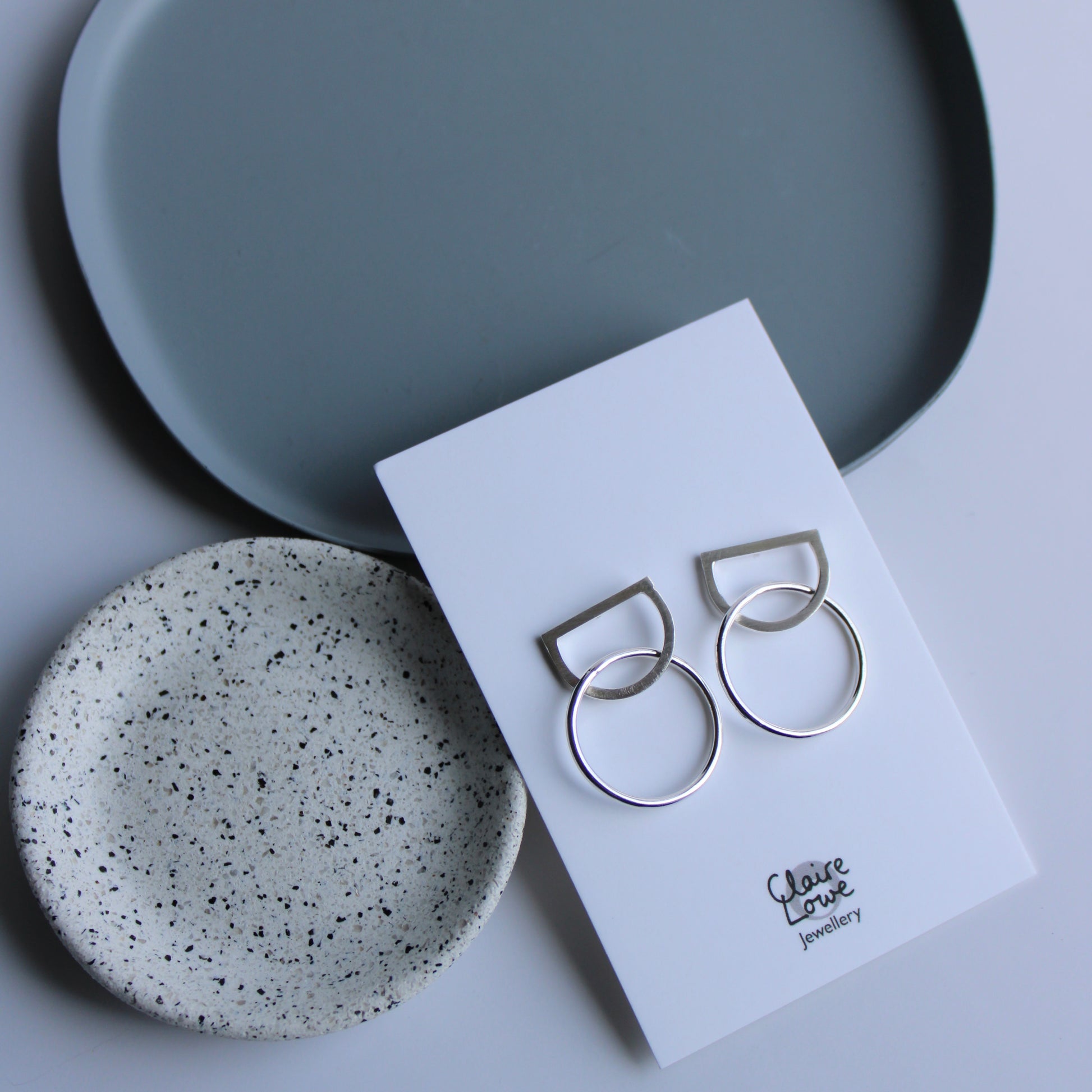 arc and circle stud earrings on an earring card