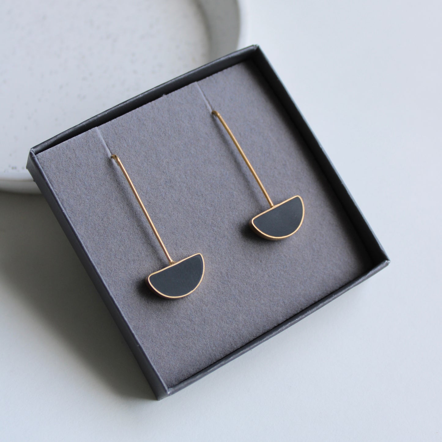 black arc and gold drop earrings in box