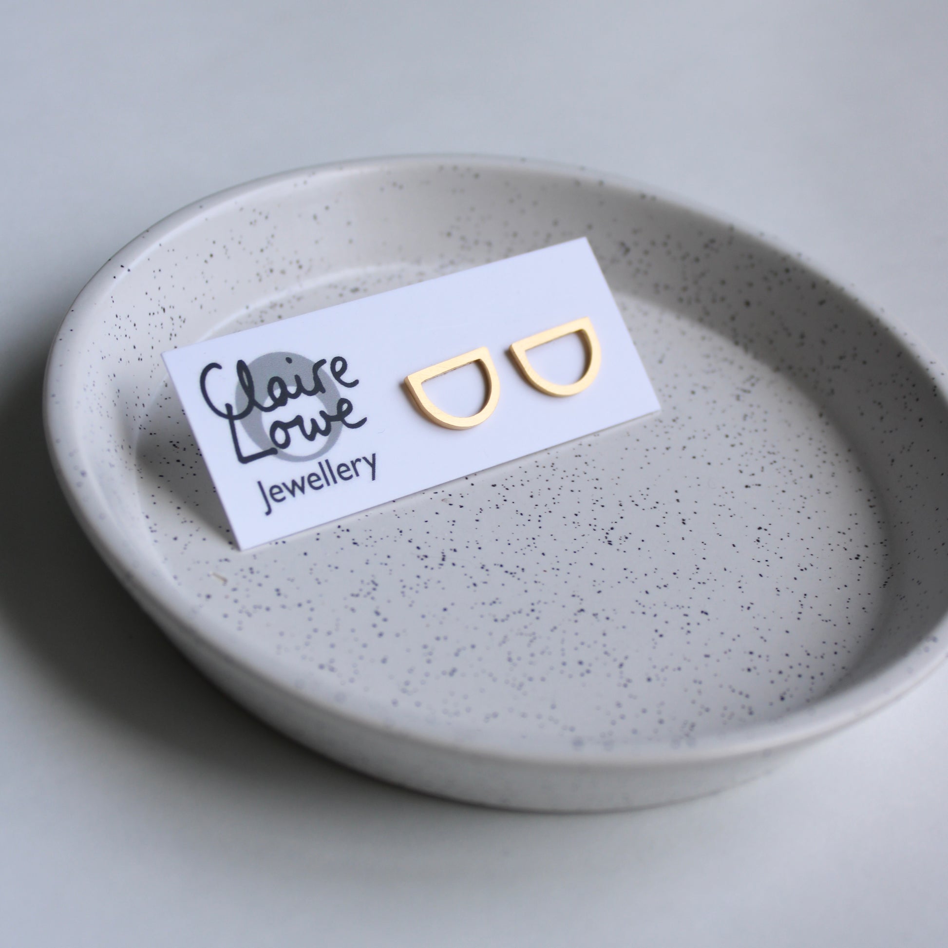arc studs gold, on an earring card