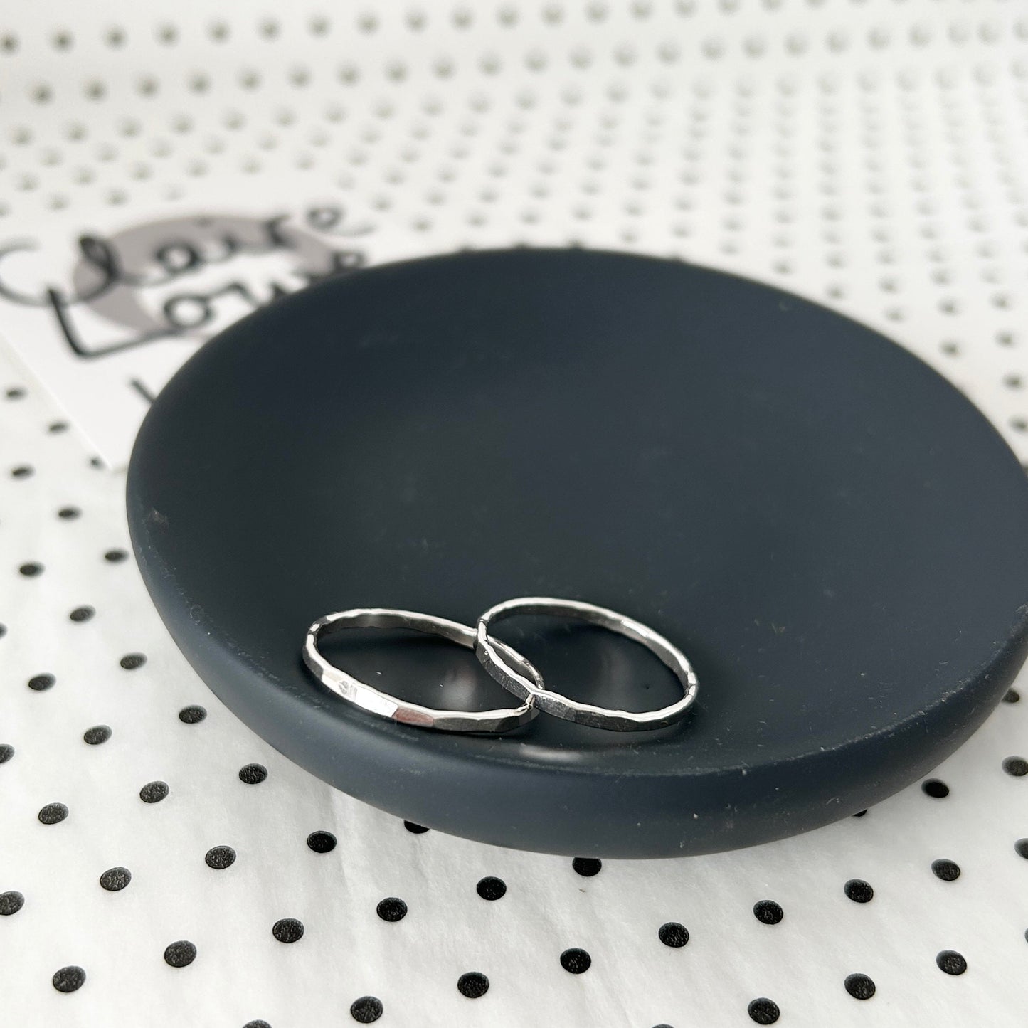 hammered silver rings on a dish