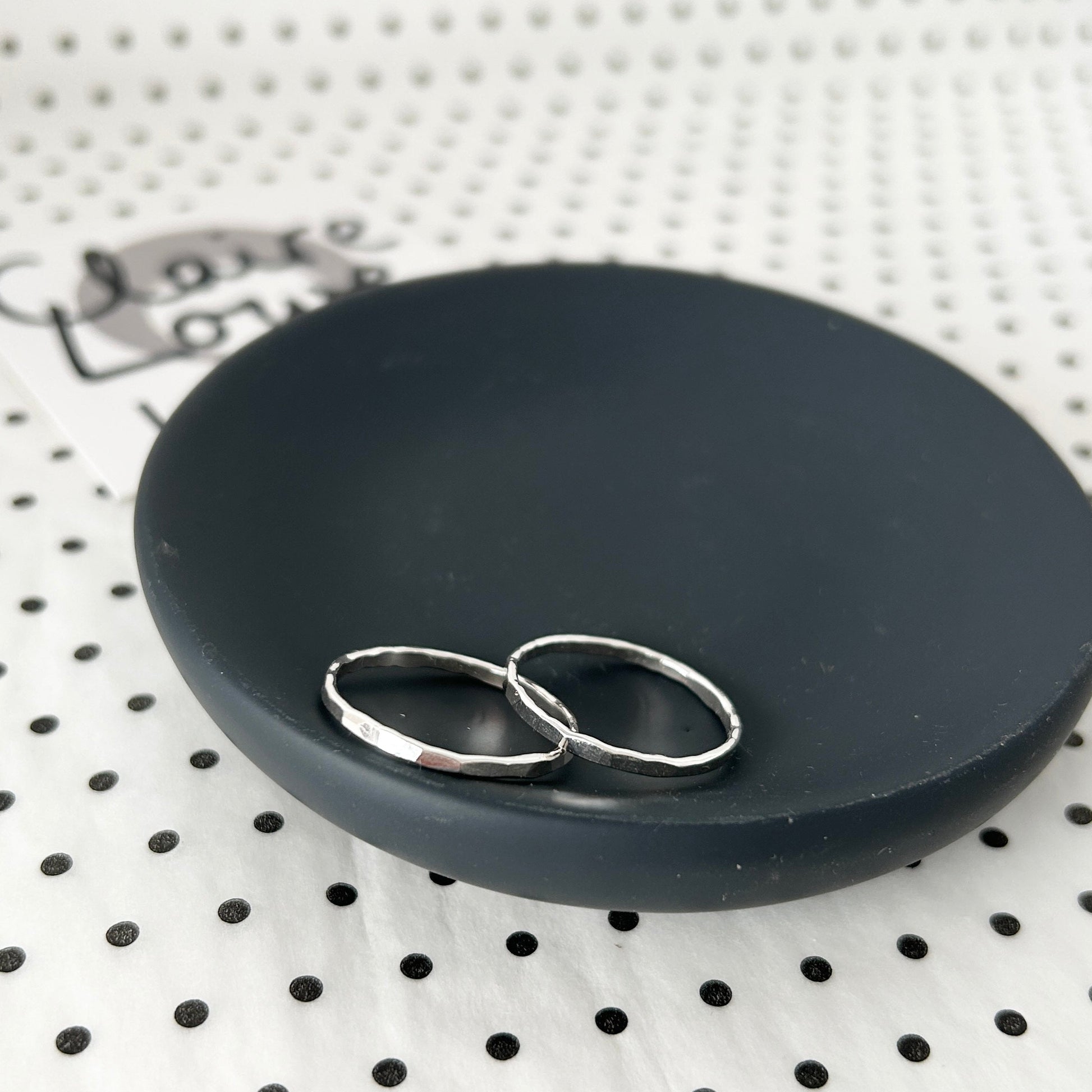 hammered silver rings on a dish