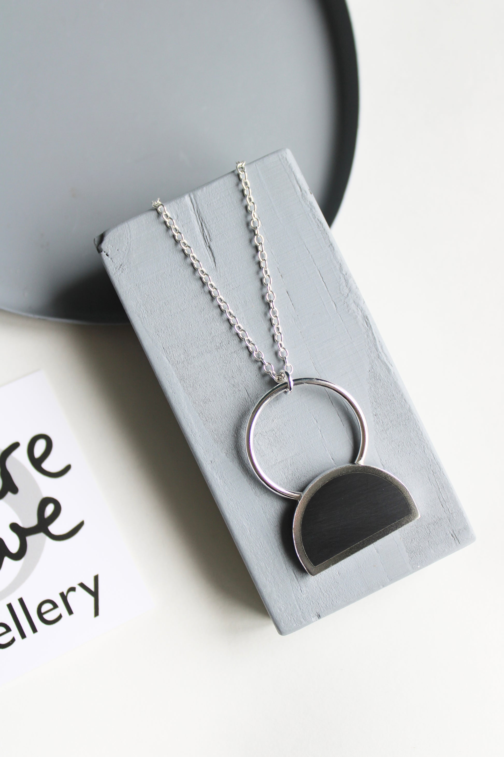 silver and black resin arc pendant