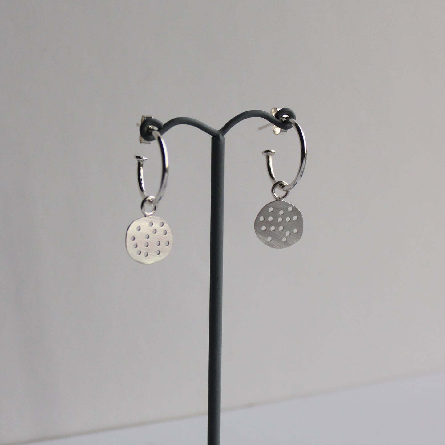silver pebble hoops on earrings stand