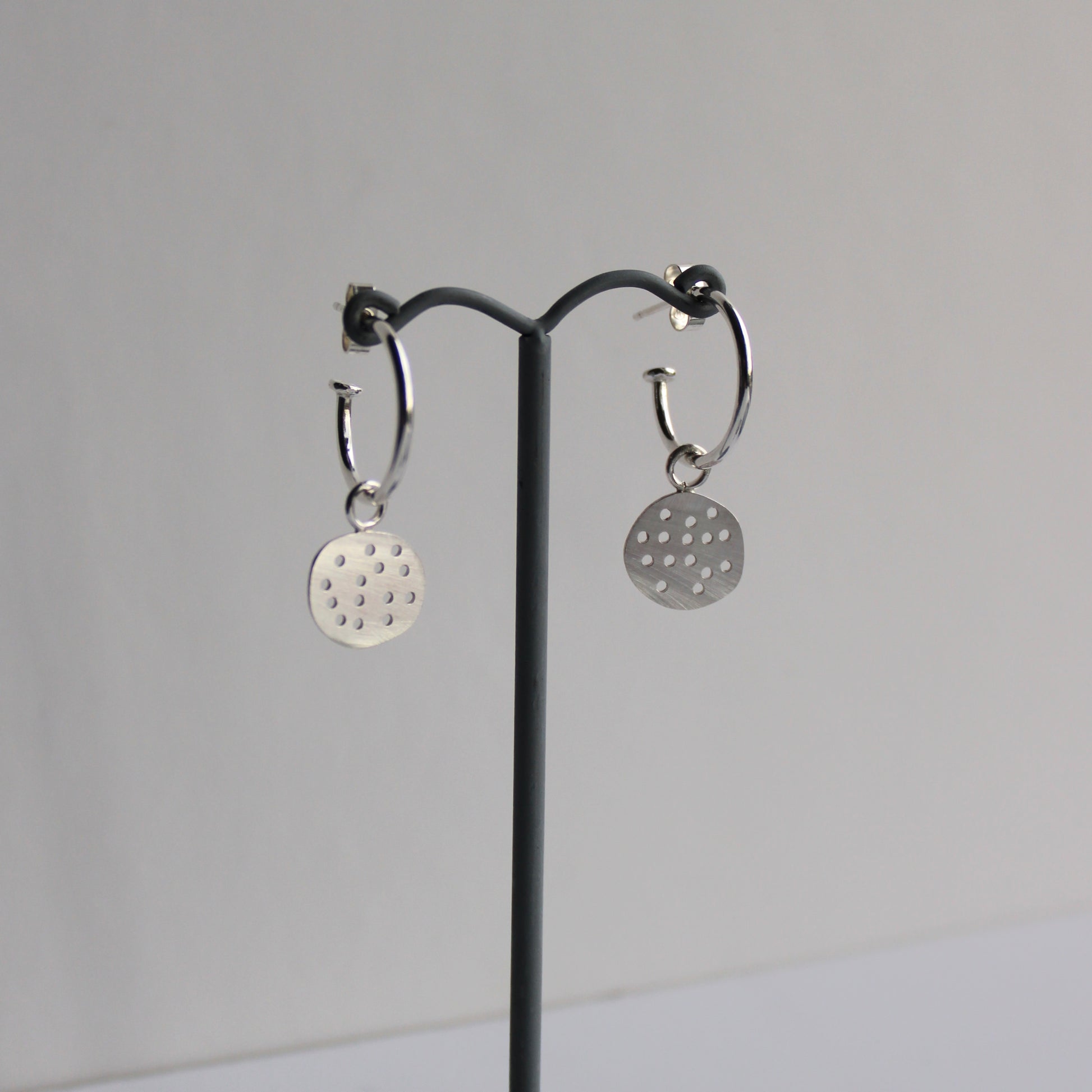 silver pebble hoops on earrings stand