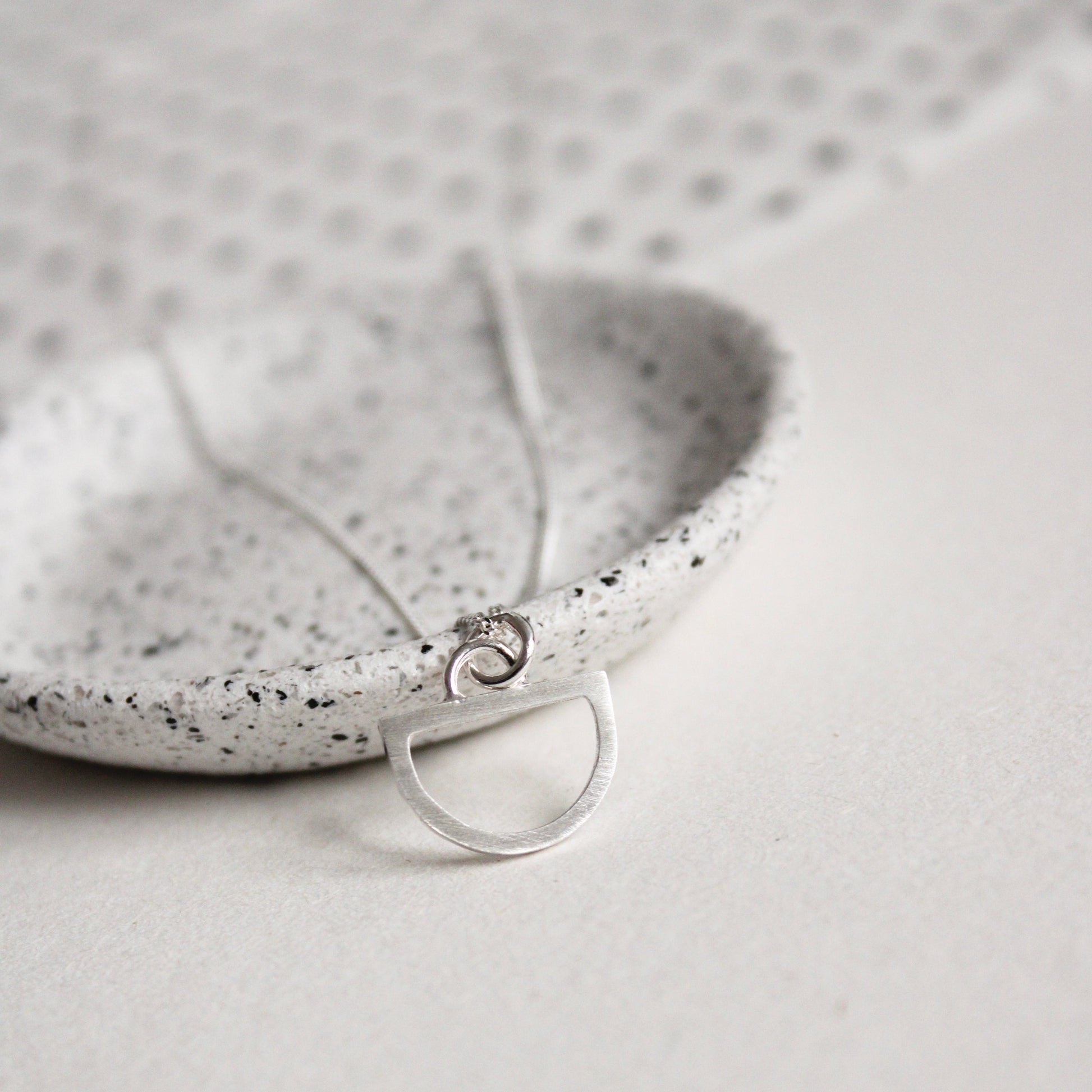 tiny silver arc pendant close up