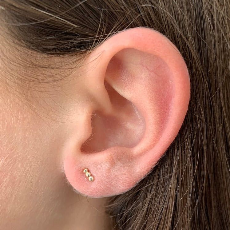 yellow gold stud earrings worn
